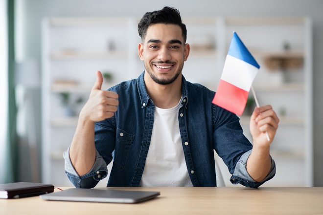 Jeune homme tenant le drapeau français et souriant