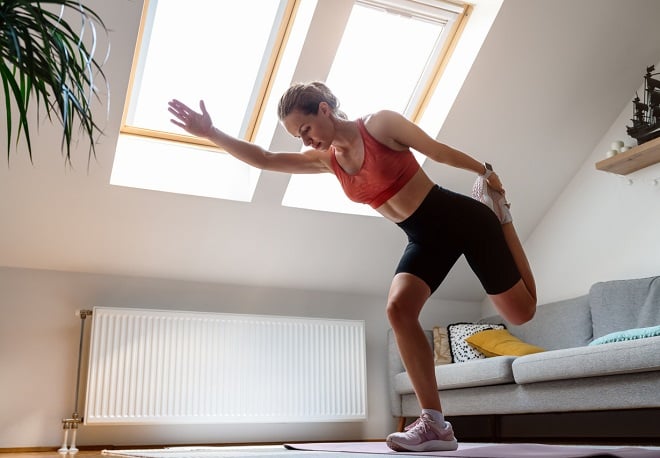 jeune femme sportive faisant un étirrement à la maison