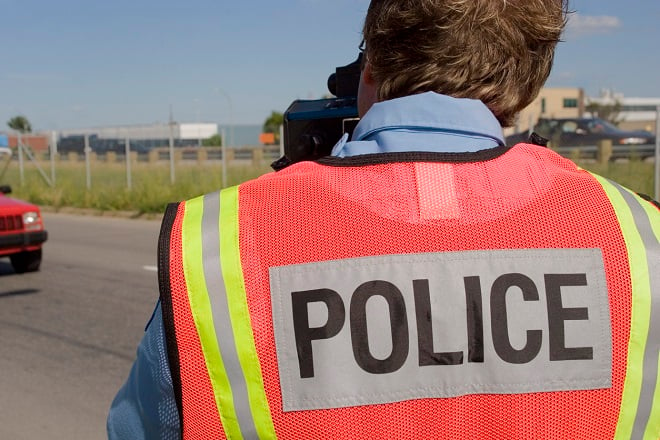 agent de police surveillant la vitesse des automobilistes avec un radar