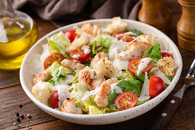 Assiette de salade César au poulet, tomates cerises et croûtons.