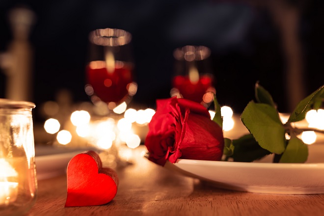 une rose et un coeur posés sur une table