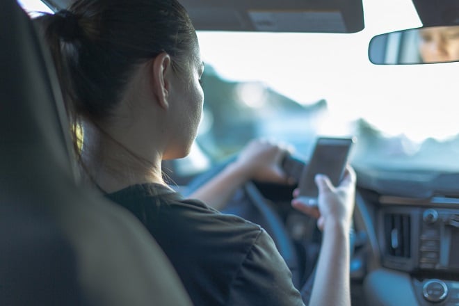 Conductrice regardant son téléphone au volant