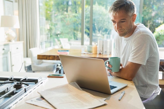 Homme faisant du télétravail et buvant son café