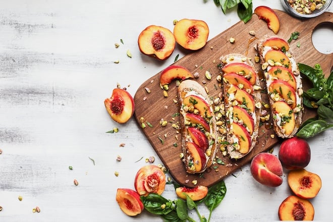 planche avec des tartines aux pêches et aux pistaches