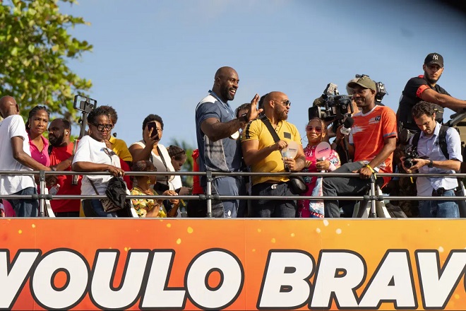 Teddy Riner dans un bus impérial saluant la foule