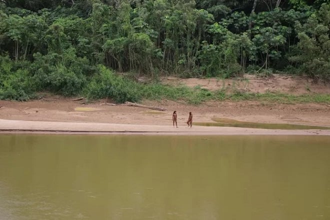 image montrant deux membres d'une tribu d'Amazonie près d'une rivière