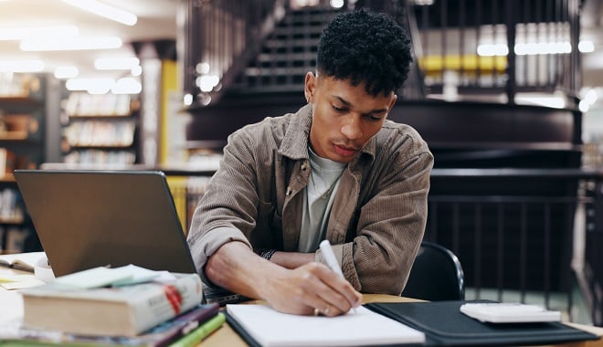 Jeune homme étudiant à la bibliothèque