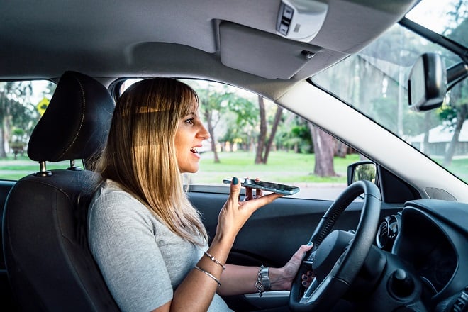 femme conduisant et envoyant un message vocal avec son téléphone